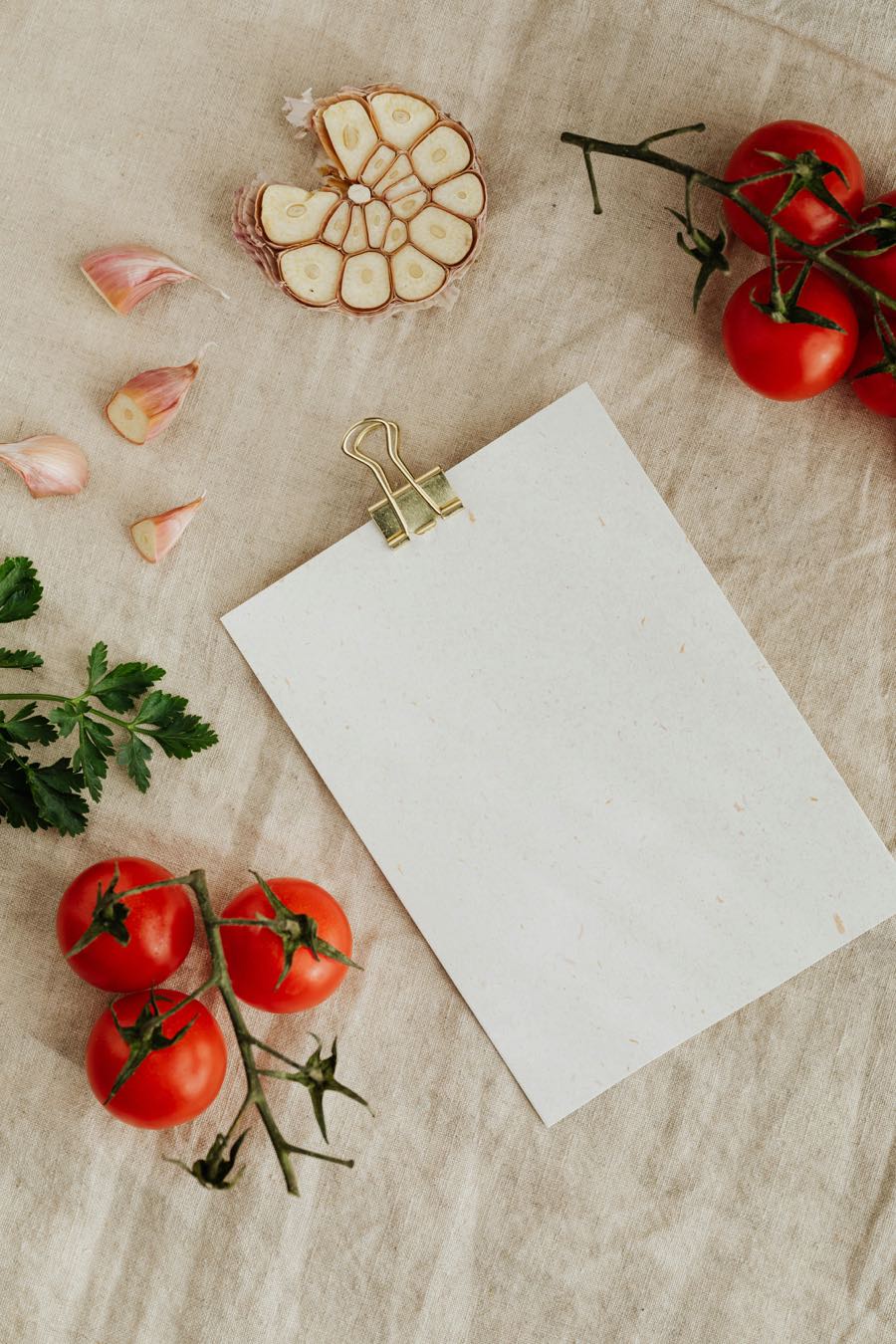 Tomates sur la vigne, ail et persil sur une nappe de lin