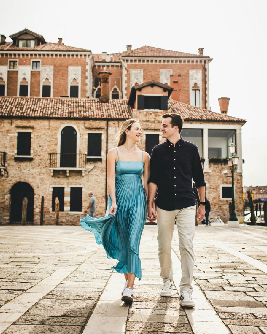 Elisabetta et Luca marchent main dans la main sur une place italienne